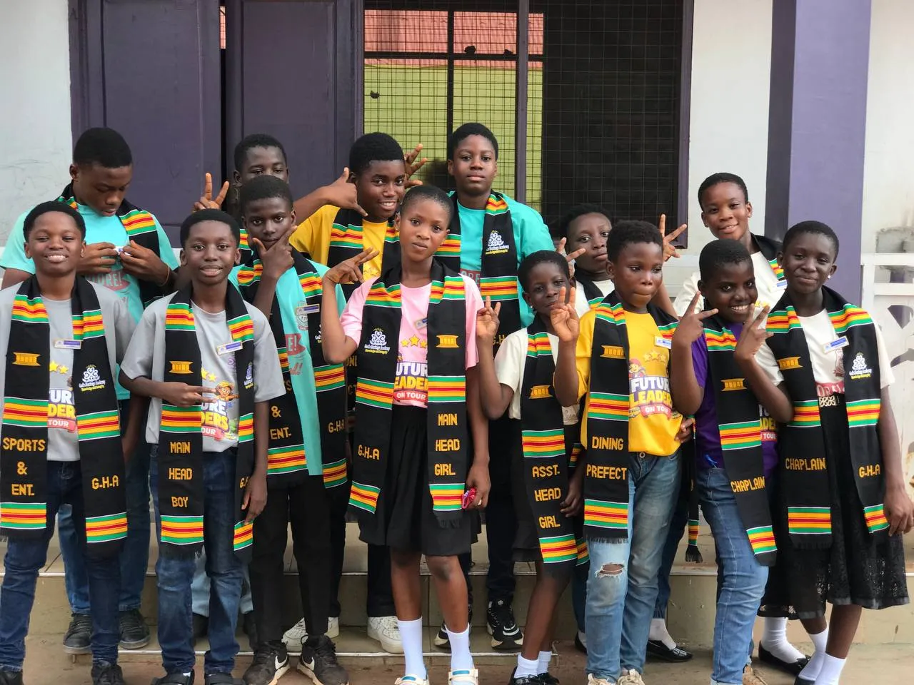 JHS prefects in kente stoles standing together on the school steps